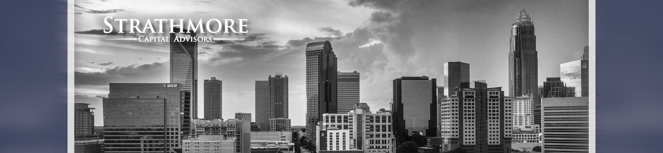Black and white city skyline with tall modern buildings and clouds in the sky. 